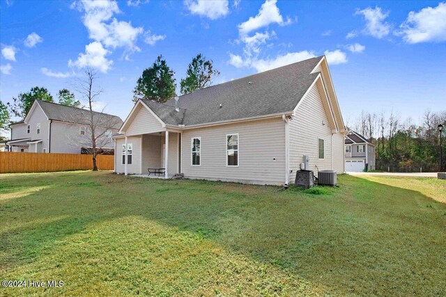 back of house featuring a lawn and central AC unit