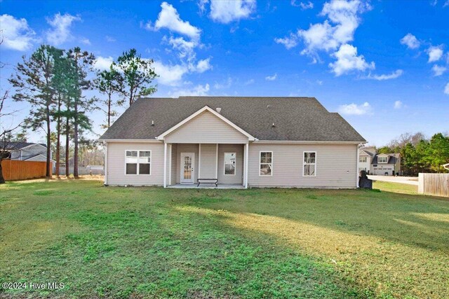 rear view of property with a lawn and a patio