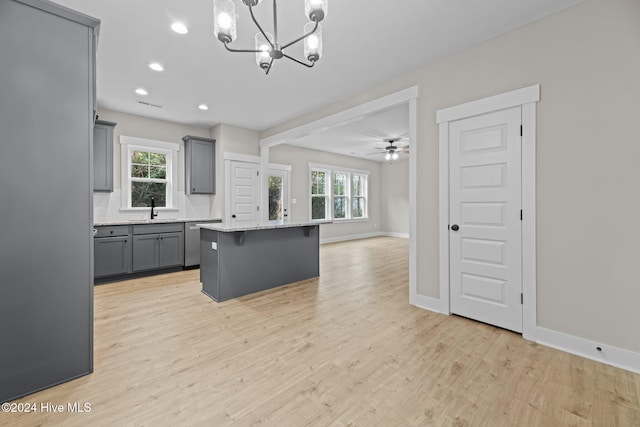 kitchen with gray cabinets, a center island, a healthy amount of sunlight, and hanging light fixtures