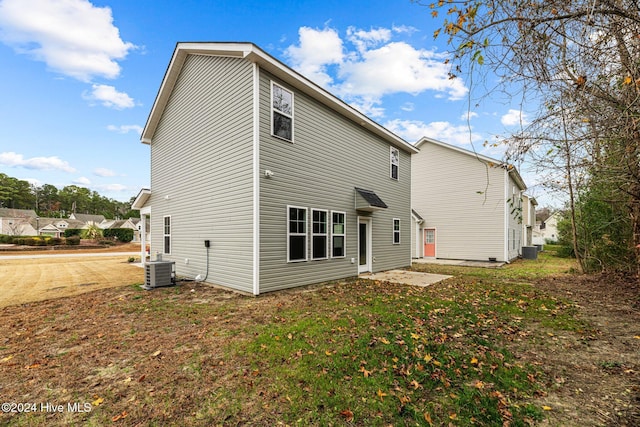 back of house featuring a lawn and central AC