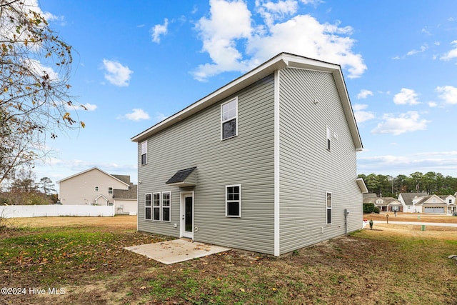 rear view of property featuring a patio area and a yard