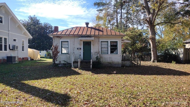 bungalow-style house featuring a front yard and central AC unit