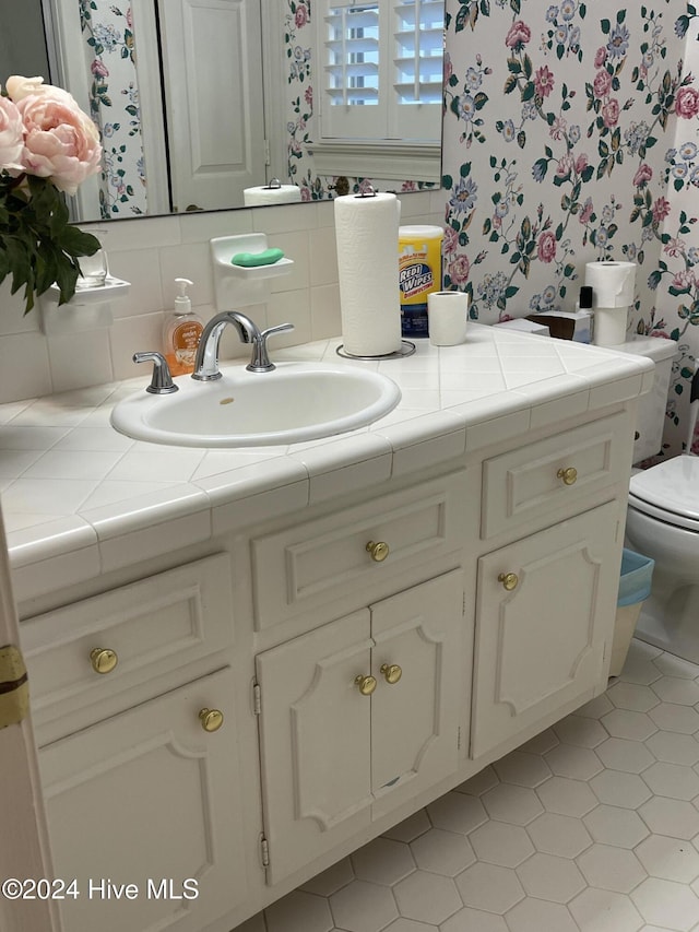 bathroom featuring tasteful backsplash, vanity, and toilet