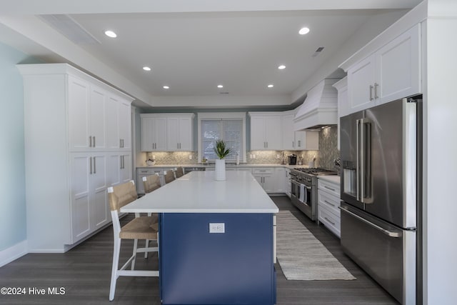 kitchen with a kitchen bar, custom range hood, a kitchen island, premium appliances, and white cabinets