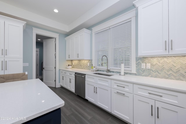 kitchen featuring sink, backsplash, dark hardwood / wood-style flooring, stainless steel dishwasher, and white cabinets