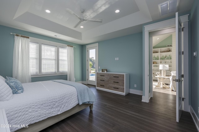 bedroom featuring a tray ceiling, ceiling fan, and dark hardwood / wood-style flooring