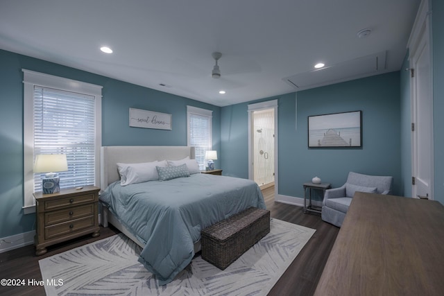 bedroom featuring dark hardwood / wood-style flooring, ensuite bath, multiple windows, and ceiling fan