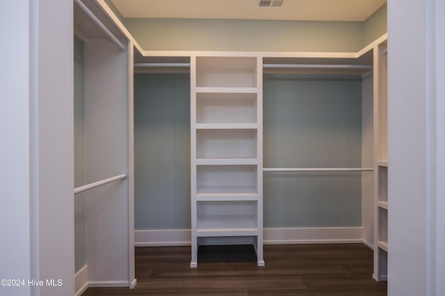 walk in closet with dark wood-type flooring