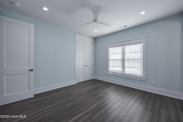 unfurnished room with ceiling fan and dark hardwood / wood-style flooring