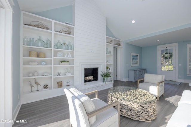 living room with a brick fireplace, high vaulted ceiling, built in features, and dark hardwood / wood-style floors