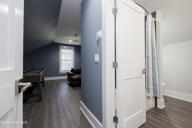 hallway with vaulted ceiling and dark hardwood / wood-style floors