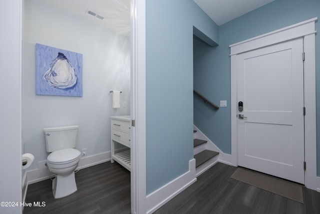 bathroom with toilet, vanity, and wood-type flooring