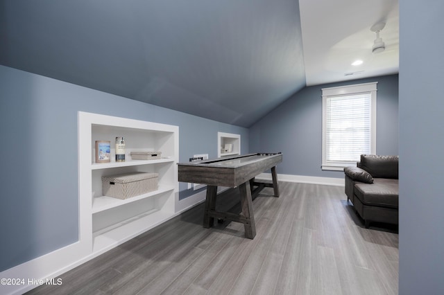 recreation room with vaulted ceiling, wood-type flooring, and built in features