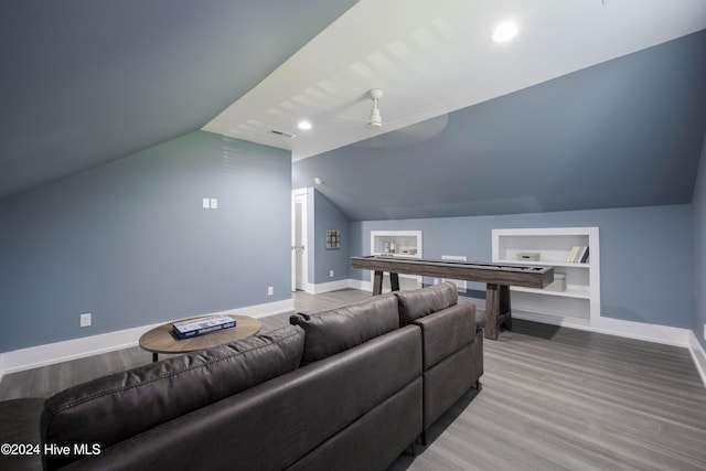 home theater with ceiling fan, wood-type flooring, vaulted ceiling, and built in shelves