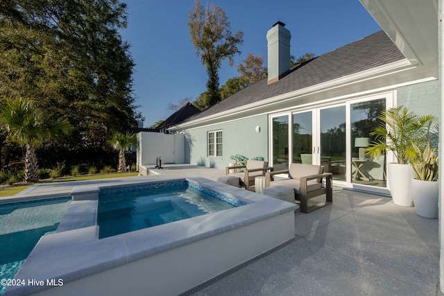 view of pool featuring an in ground hot tub and a patio