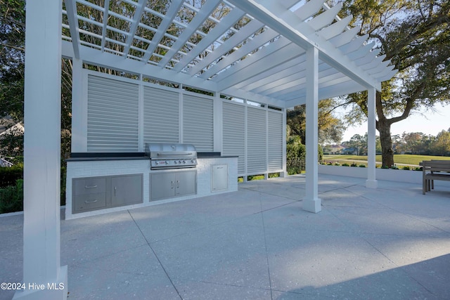 view of patio with area for grilling, a pergola, and a grill