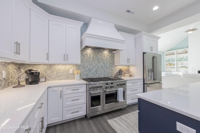 kitchen with white cabinets, tasteful backsplash, premium appliances, and premium range hood