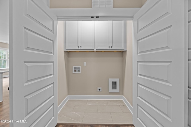 washroom with cabinets, hookup for a washing machine, light hardwood / wood-style floors, and hookup for an electric dryer