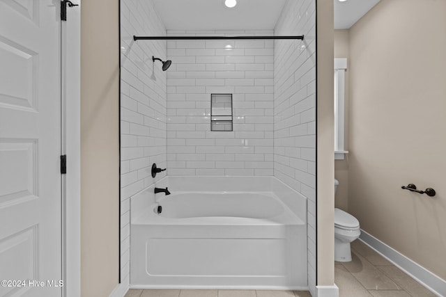 bathroom with toilet, tile patterned floors, and tiled shower / bath