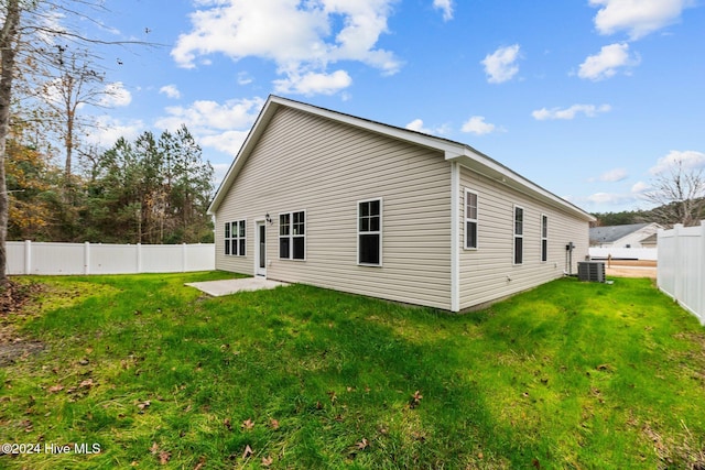 back of house featuring a lawn and central AC