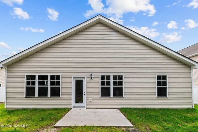 back of house featuring a lawn and a patio