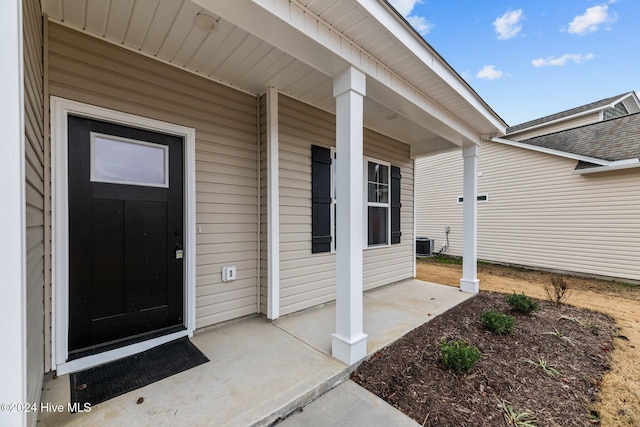 doorway to property with a porch and cooling unit