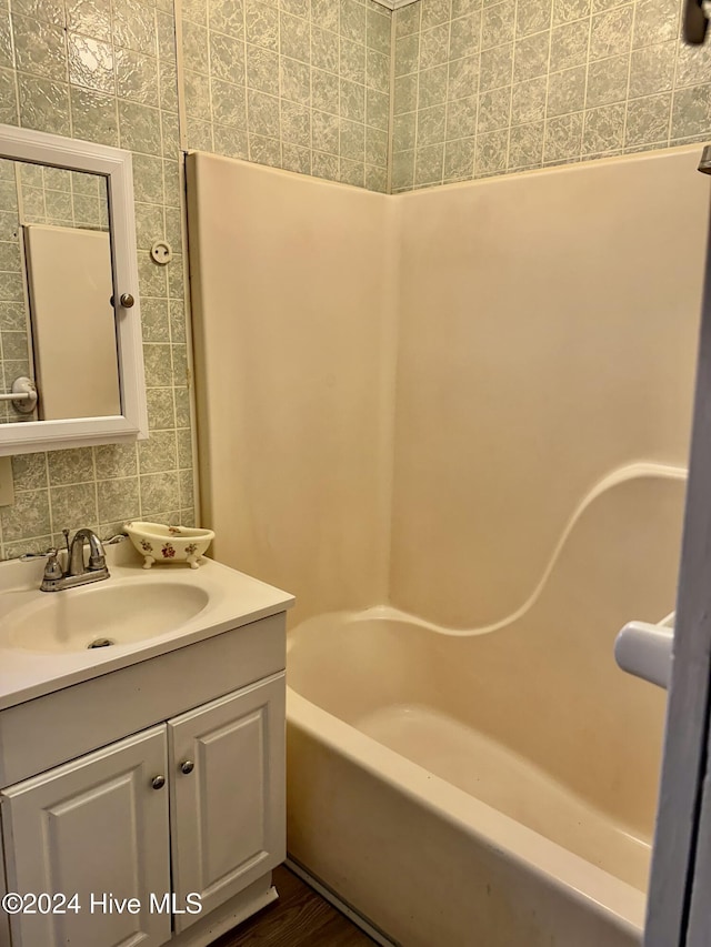 bathroom featuring tasteful backsplash, vanity, and tub / shower combination