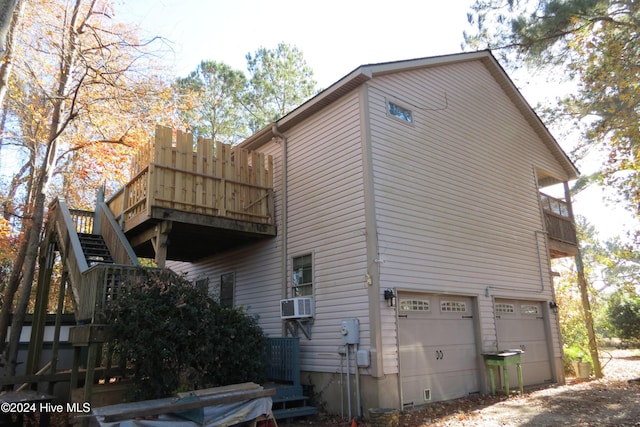 view of side of home featuring cooling unit and a garage