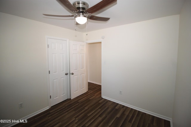 unfurnished bedroom featuring dark wood-type flooring, ceiling fan, and a closet