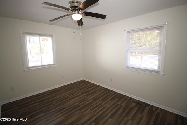 spare room with dark hardwood / wood-style flooring and a wealth of natural light