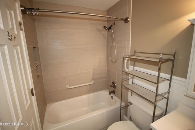 bathroom with tiled shower / bath combo and toilet