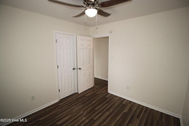 unfurnished bedroom featuring dark wood-type flooring and ceiling fan