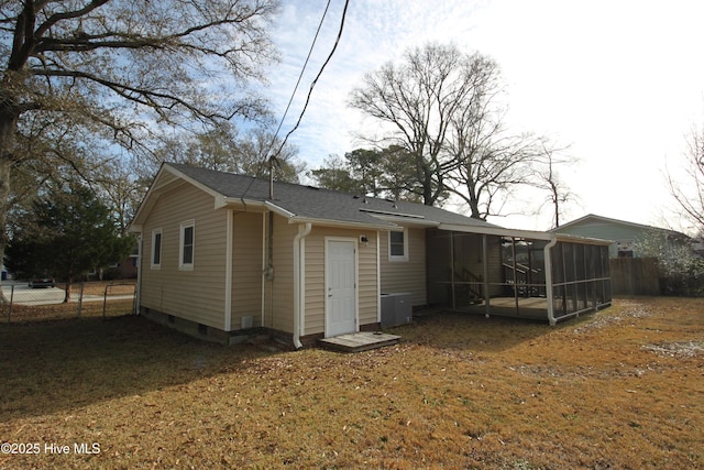 rear view of house with a sunroom and a lawn