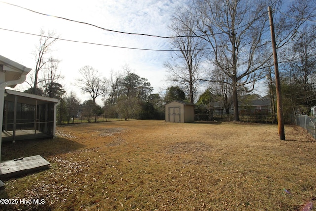 view of yard featuring a sunroom and a shed