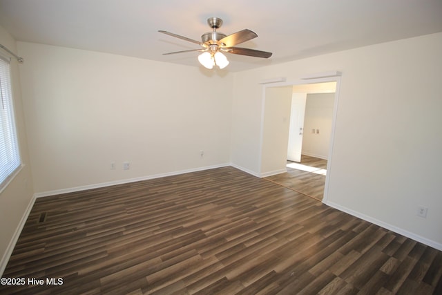 empty room with dark hardwood / wood-style flooring, plenty of natural light, and ceiling fan