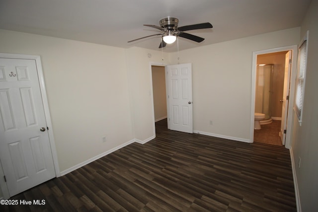 unfurnished bedroom with dark wood-type flooring, ensuite bath, and ceiling fan