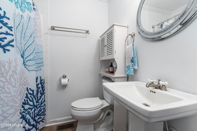 bathroom featuring curtained shower, toilet, and sink