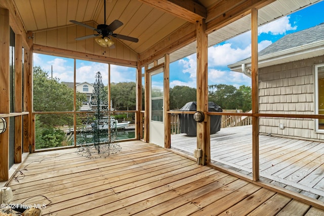 unfurnished sunroom featuring lofted ceiling with beams and ceiling fan