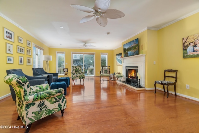 living room with ceiling fan, crown molding, and light hardwood / wood-style floors