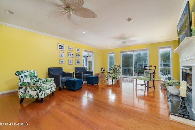 living area with ceiling fan, light hardwood / wood-style floors, and crown molding