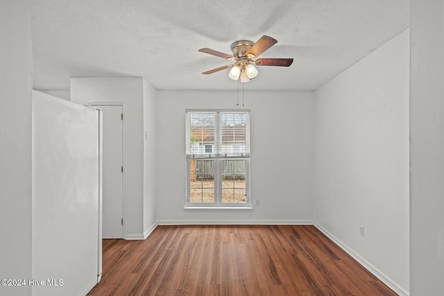 spare room featuring ceiling fan, dark hardwood / wood-style flooring, and a textured ceiling