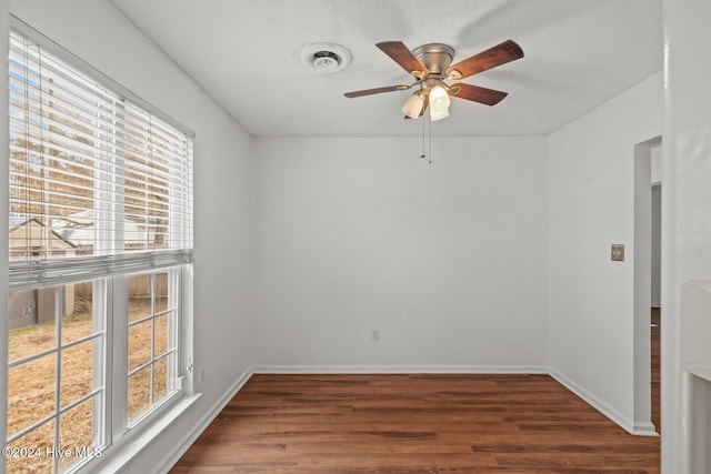 empty room with ceiling fan and dark wood-type flooring