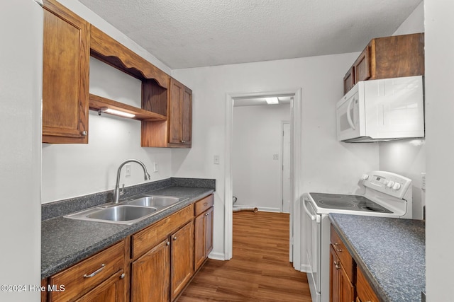 kitchen with dark hardwood / wood-style flooring, range with electric cooktop, sink, and a textured ceiling