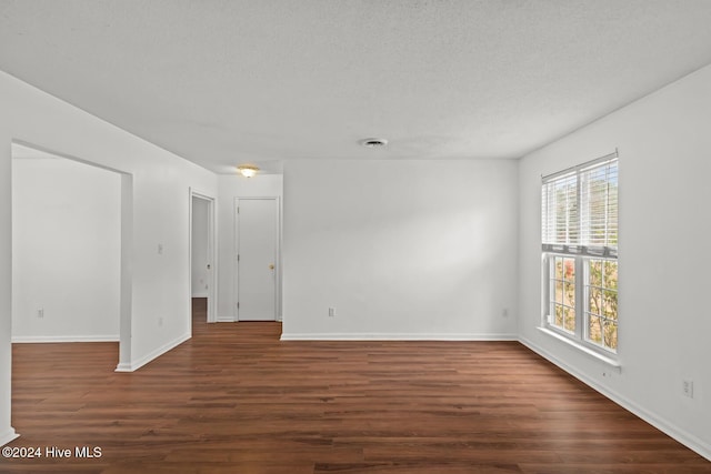 unfurnished room with dark hardwood / wood-style floors and a textured ceiling