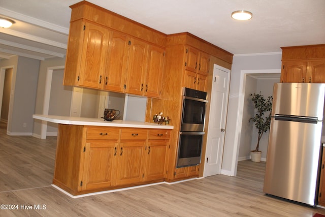 kitchen with kitchen peninsula, light wood-type flooring, stainless steel appliances, and ornamental molding