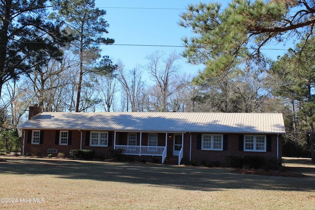 single story home featuring covered porch and a front lawn