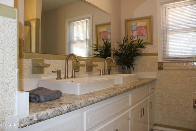 bathroom featuring plenty of natural light, tile walls, and vanity