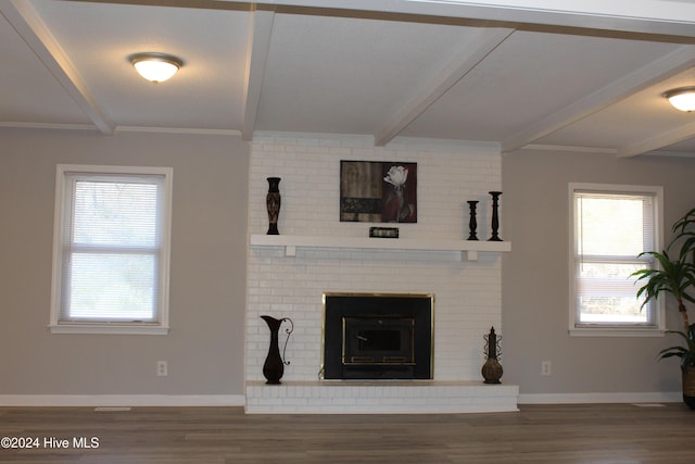 living room with beamed ceiling, wood-type flooring, a brick fireplace, and ornamental molding