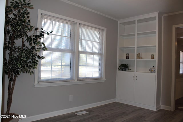 empty room featuring crown molding and dark wood-type flooring