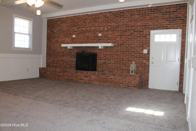 unfurnished living room with carpet, ceiling fan, and a healthy amount of sunlight